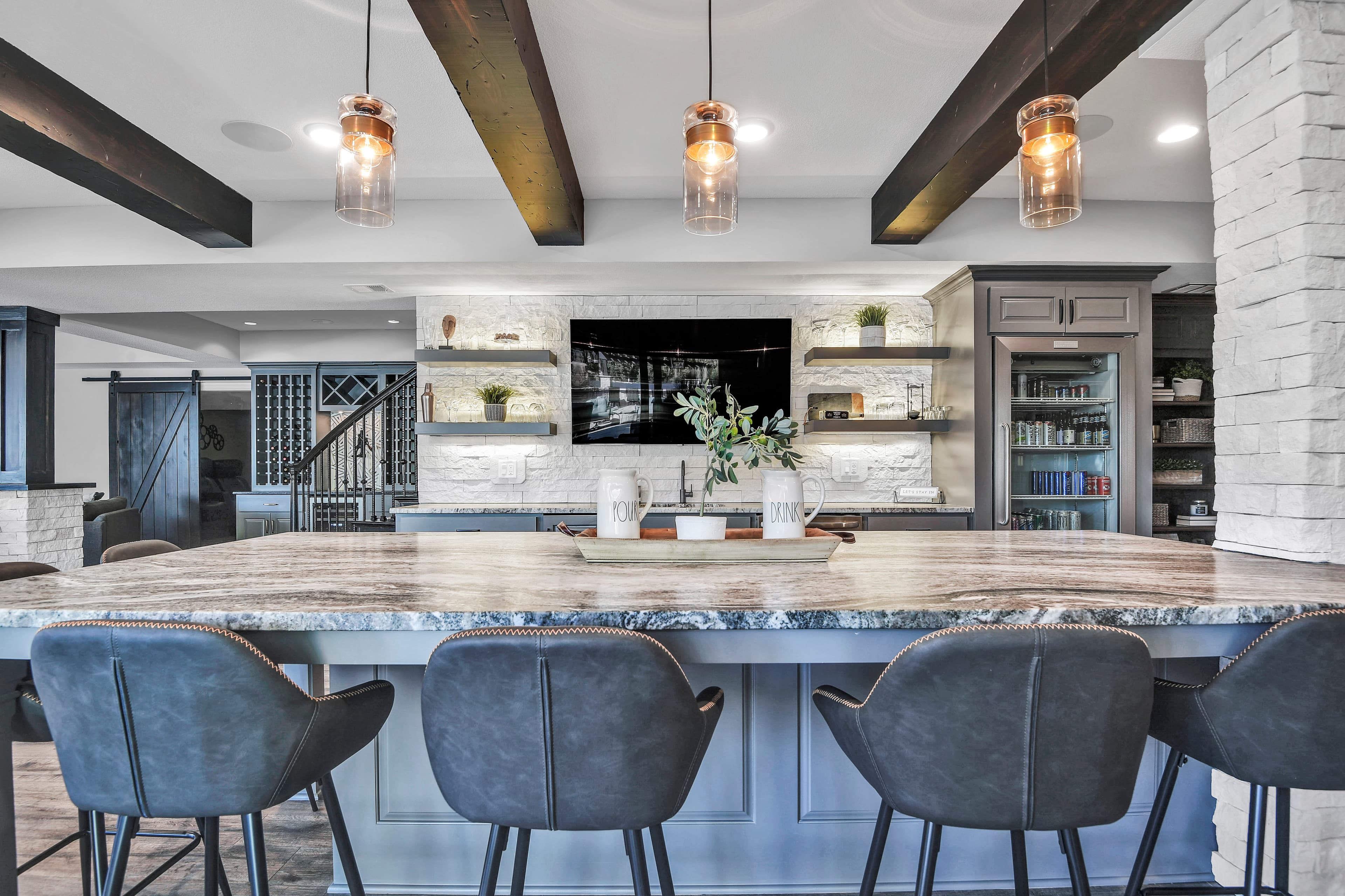 Finished lower-level bar and lounge staged with polished buyer-ready details