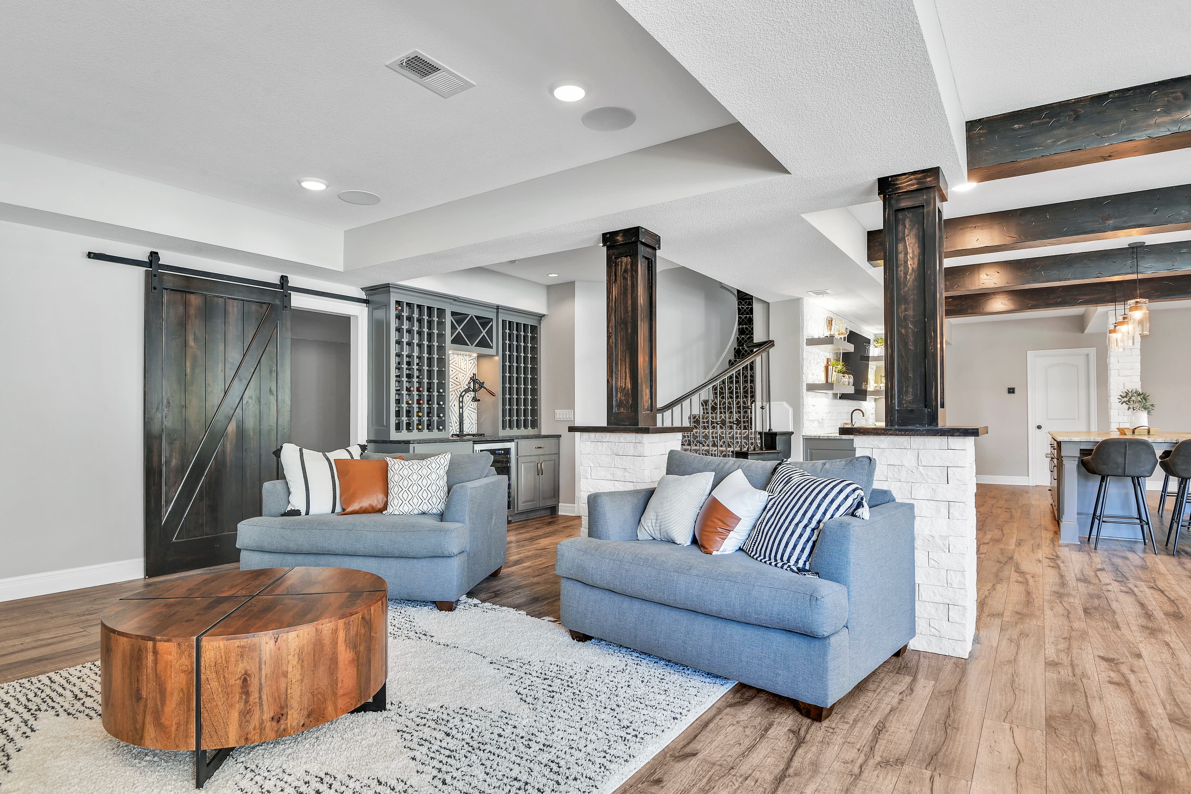 Finished lower-level lounge staged with layered seating and warm wood details