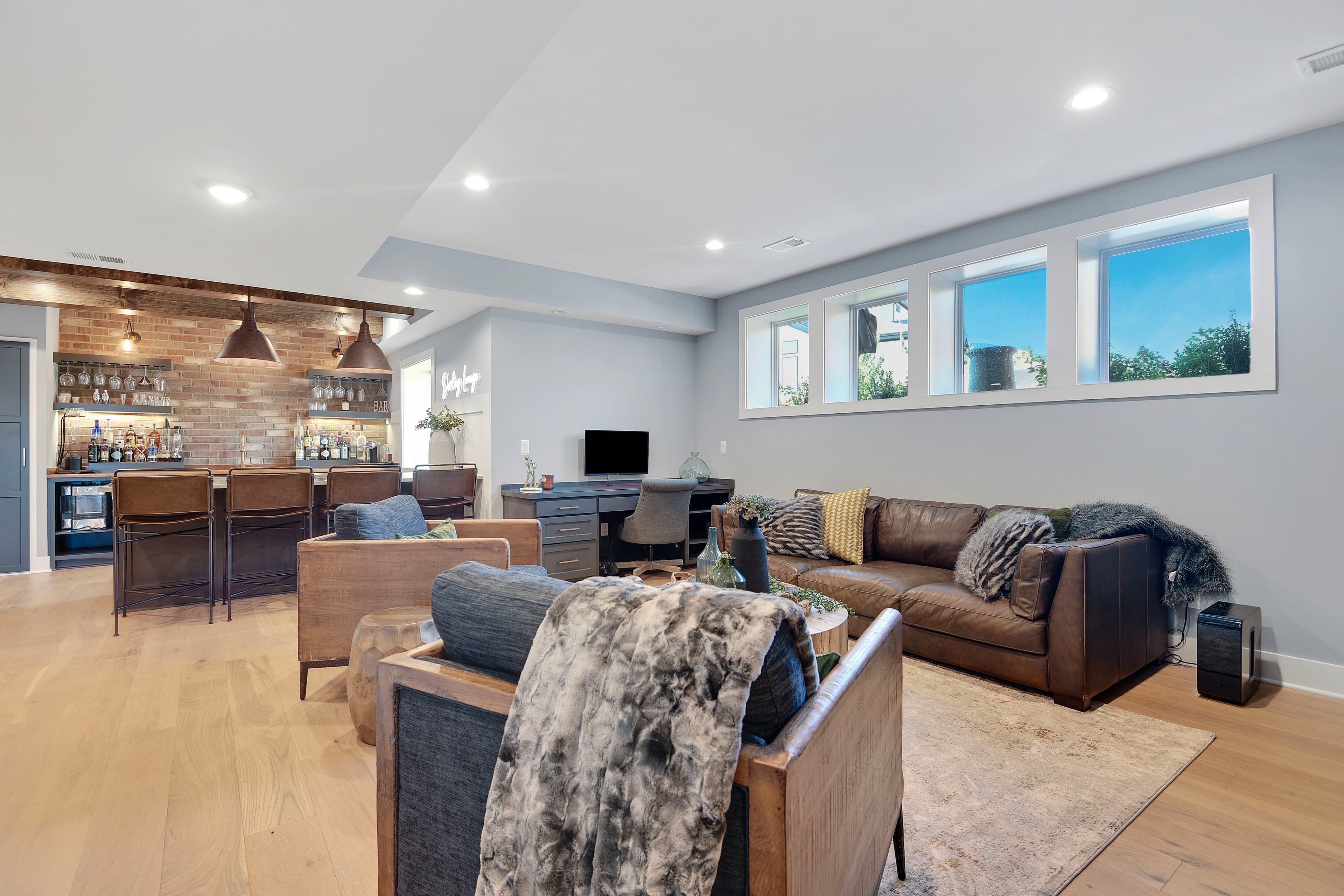 Polished bar lounge staged with leather seating, brick detail, and warm listing-ready styling