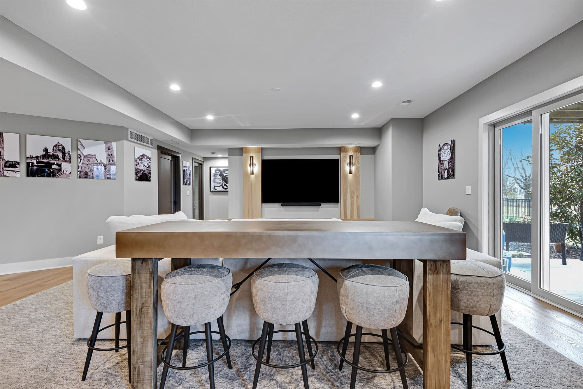 Contemporary staged media room with a custom television wall, console table, and upholstered seating