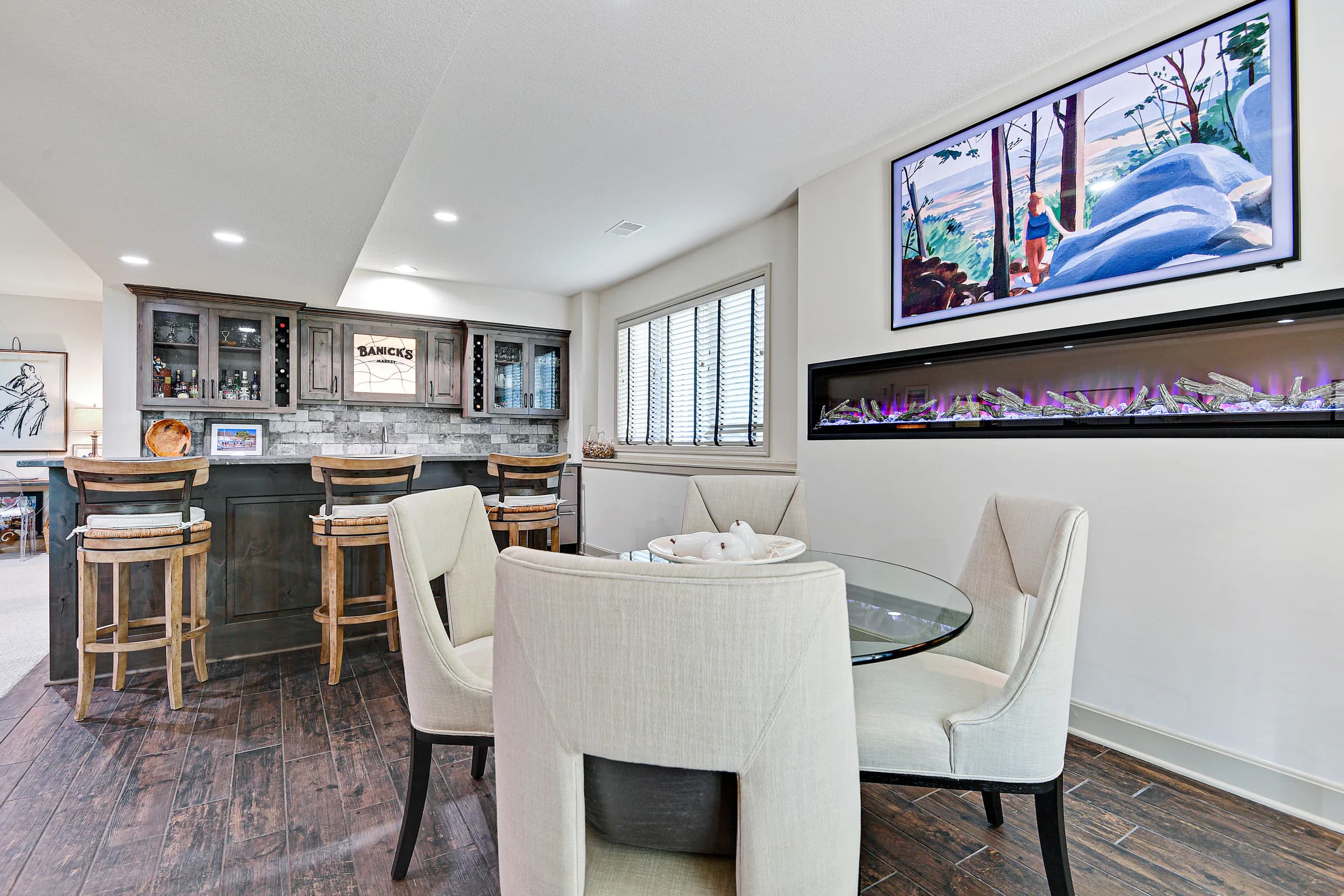Professionally staged entertaining room with a home bar, dining area, and fireplace