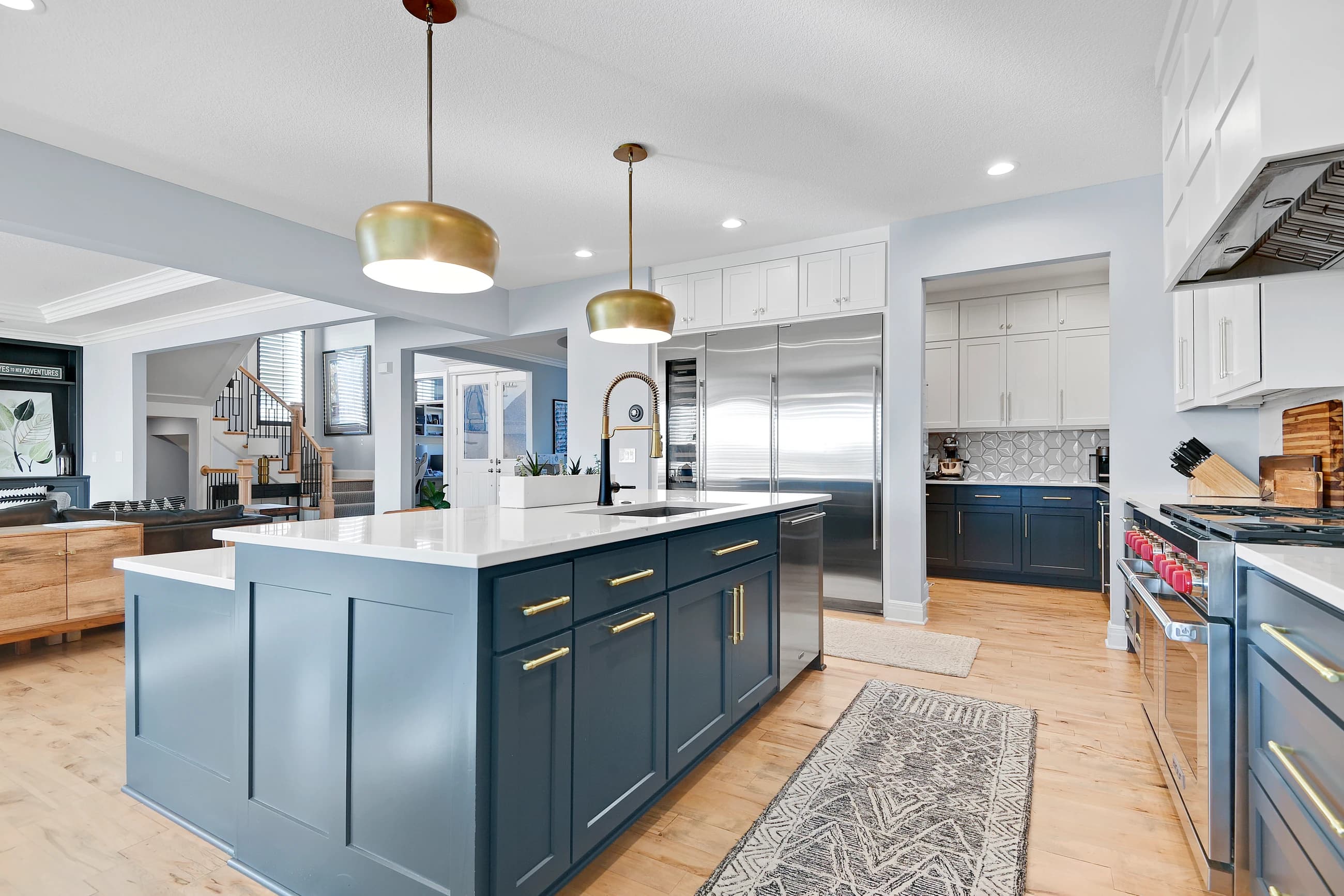 Open kitchen with a navy island and adjoining living areas staged for buyer clarity