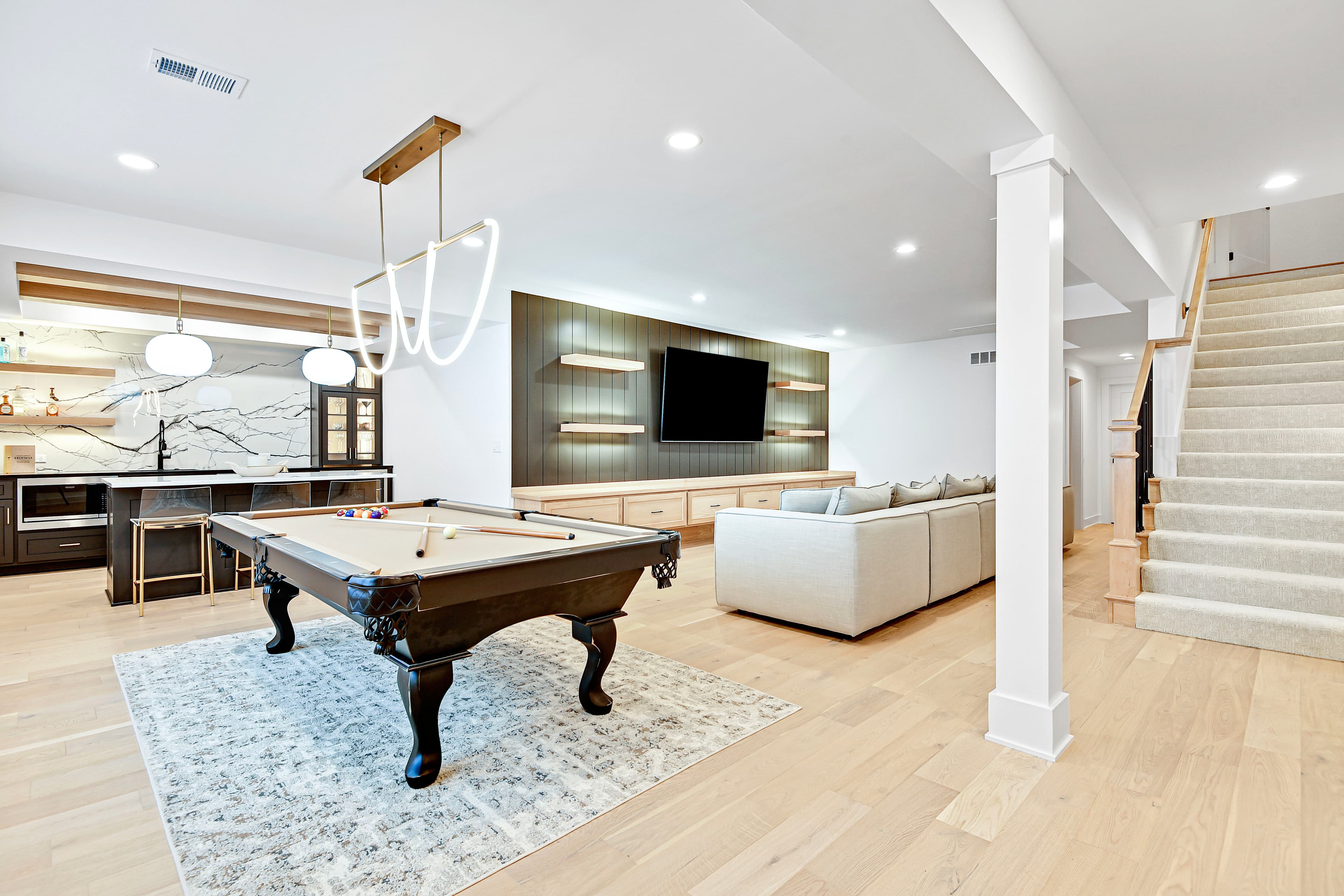 Finished lower-level lounge with pool table and sectional seating