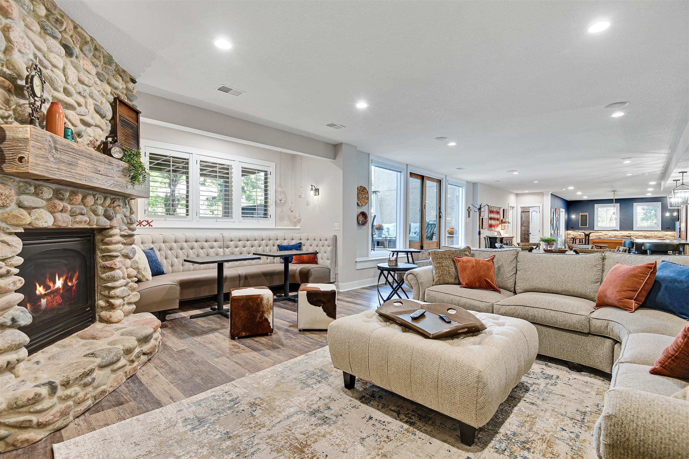 Welcoming staged great room centered around a stone fireplace
