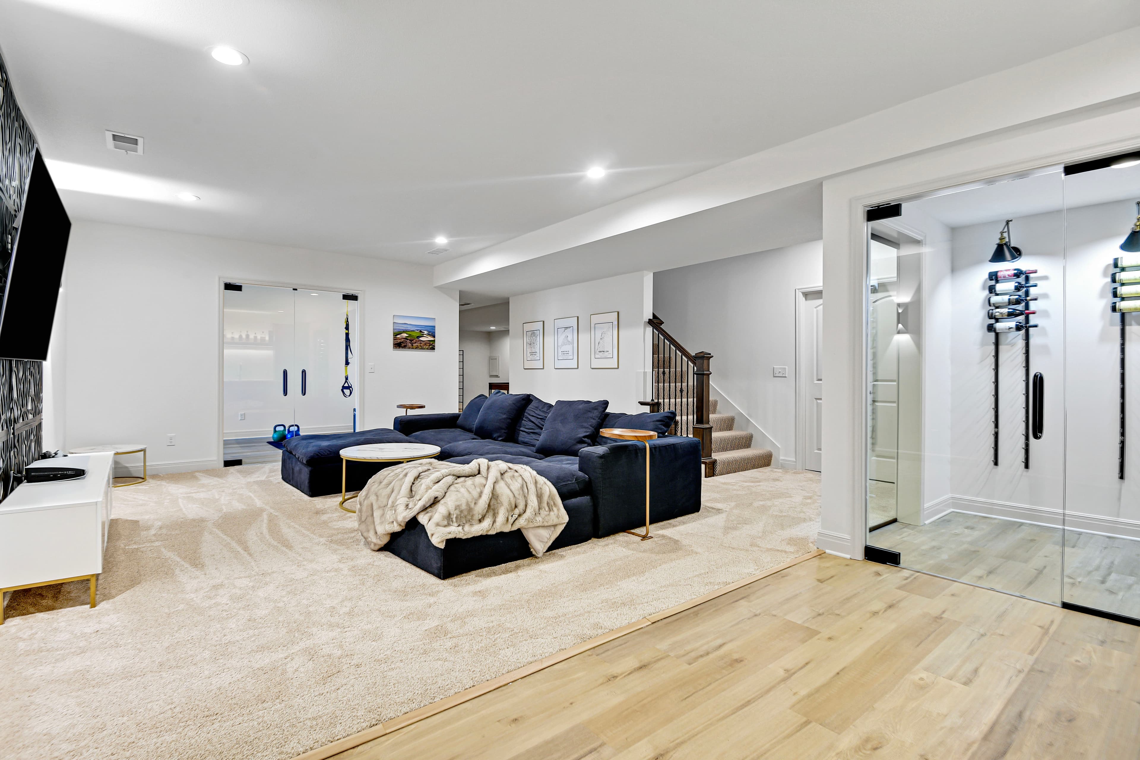 Lounge with navy sectional and a glass wine room